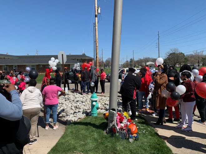 Michael Duerson III's family and friends gather around a memorial near where Duerson was shot