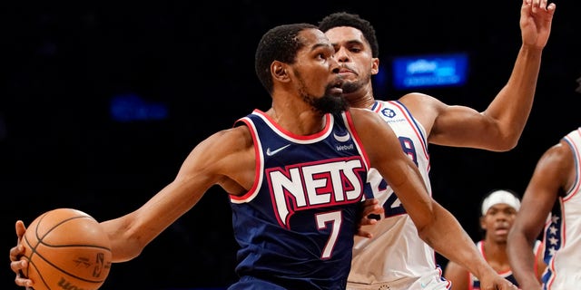 Brooklyn Nets forward Kevin Durant (7) drives to the basket against Philadelphia 76ers forward Tobias Harris (12) during the second half of an NBA basketball game, Thursday, Dec. 16, 2021, in New York. The Nets won 114-105. 