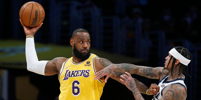 Los Angeles Lakers forward LeBron James (6) is defended by Utah Jazz guard Jordan Clarkson, right, during the first half of an NBA basketball game in Los Angeles, Monday, Jan. 17, 2022. 