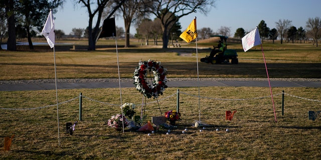 Workers prepare the course for the day near a makeshift memorial at the Rockwind Community Links Thursday, March 17, 2022, in Hobbs, New Mexico. The memorial was for student golfers and the coach of University of the Southwest killed in a crash in Texas. 