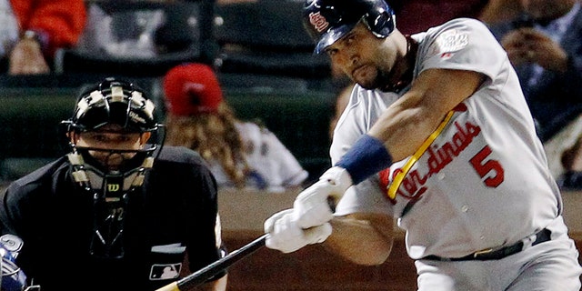 St. Louis Cardinals' Albert Pujols hits a solo home run during the ninth inning of Game 3 of baseball's World Series against the Texas Rangers in Arlington, Texas, in this Saturday, Oct. 22, 2011, file photo. 