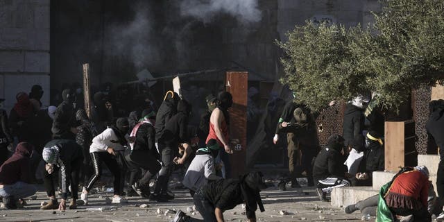 Palestinians clash with Israeli security forces at the Al Aqsa Mosque compound in Jerusalem's Old City Friday, April 15, 2022. 