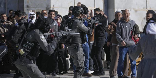 Israeli security forces take position during clashes with Palestinians demonstrators at the Al Aqsa Mosque compound in Jerusalem's Old City, Friday, April 15, 2022. 