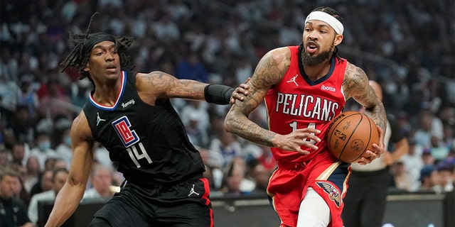 New Orleans Pelicans forward Brandon Ingram, right, drives past Los Angeles Clippers guard Terance Mann during the first half of an NBA basketball play-in tournament game Friday, April 15, 2022, in Los Angeles.