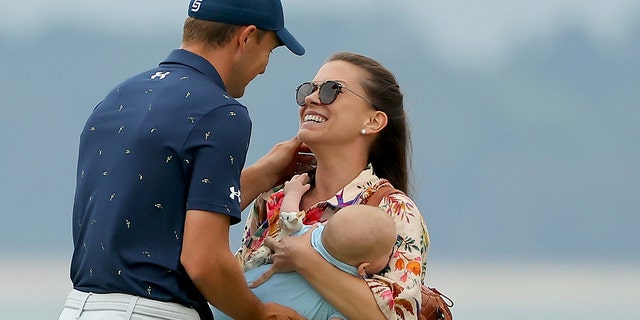 Jordan Spieth and wife Annie Verret celebrate with son Sammy on the 18th green after Spieth beat Patrick Cantlay in a playoff to win the RBC Heritage at Harbor Town Golf Links on April 17, 2022 in Hilton Head Island, South Carolina.