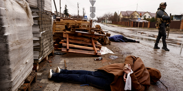 GRAPHIC IMAGE WARNING: A body with hands bound by white cloth, who according to residents was shot by Russian soldiers, lies in the street in Bucha, Ukraine, on Sunday.