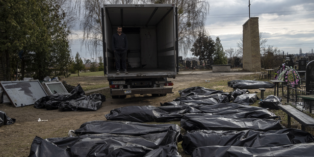 WARNING: GRAPHIC IMAGE: A cemetery worker waits in a truck before colleagues start to load the corpses of civilians killed in Bucha, before transporting them to the morgue, on the outskirts of Kyiv, Ukraine, on Wednesday.