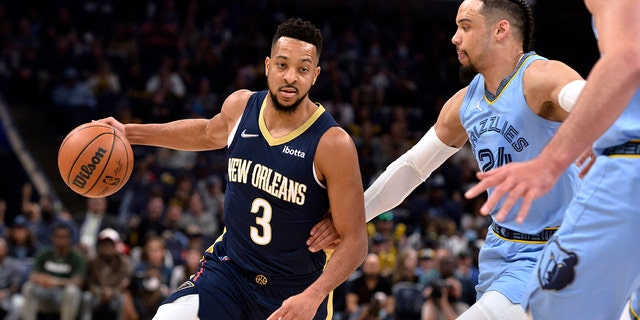 New Orleans Pelicans guard CJ McCollum drives on Grizzlies forward Dillon Brooks Saturday, April 9, 2022, in Memphis, Tennessee.