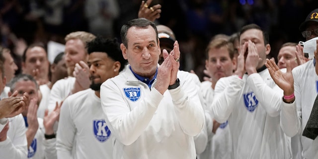 Surrounded by former players, Duke coach Mike Krzyzewski applauds while being recognized prior to the team's NCAA college basketball game against North Carolina in Durham, N.C., Saturday, March 5, 2022. The matchup is Krzyzewski's final game at Cameron Indoor Stadium. (AP Photo/Gerry Broome)