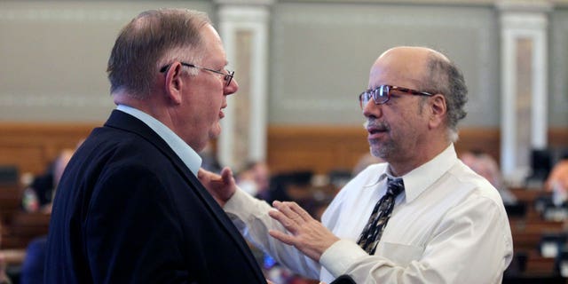 Kansas House Majority Leader Dan Hawkins, left, R-Wichita, confers with Minority Leader Tom Sawyer, D-Wichita, during a debate on a bill barring transgender athletes from competing in female school sports, Friday, April 1, 2022, at the Statehouse in Topeka, Kan. 