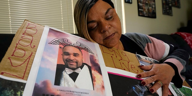 Penelope Scott holds a collection of family photos including one of her son, De'vazia Turner, one of the victims killed in a mass shooting, during an interview with The Associate Press in Elk Grove, Calif., Monday, April 4, 2022. Multiple people were killed and injured in the shooting a day earlier. 