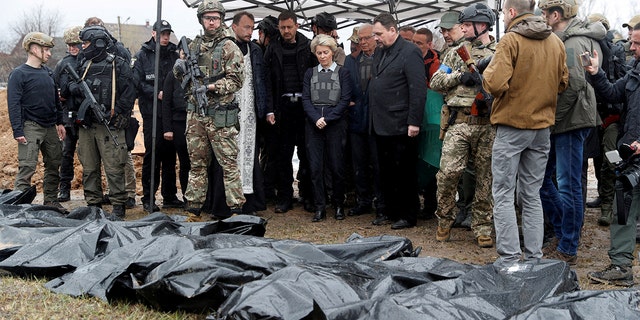 European Commission President Ursula von der Leyen, High Representative of the European Union for Foreign Affairs and Security Policy Josep Borrell, Slovakia's Prime Minister Eduard Heger and Ukraine's Prime Minister Denys Shmyhal stand next to a mass grave as they visit the town of Bucha, as Russia's attack on Ukraine continues, outside of Kyiv, Ukraine April 8, 2022. 