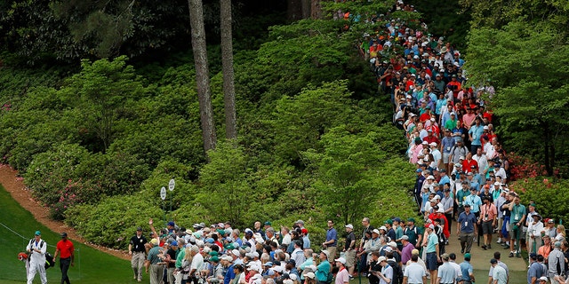 Tiger Woods walks onto the 6th hole as patrons gather during the Masters at Augusta National Golf Club on April 14, 2019. 