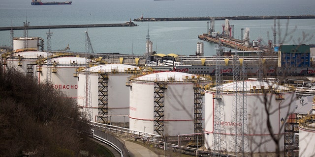 Oil storage tanks stand at the RN-Tuapsinsky refinery, operated by Rosneft Oil Co., as tankers sail beyond in Tuapse, Russia, on Monday, March 23, 2020. Photographer: Andrey Rudakov/Bloomberg via Getty Images