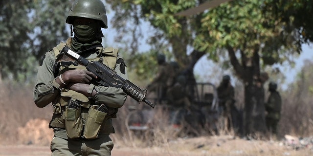 An Ivorian soldier provides security on arrival of Ivorian Prime Minister Patrick Achi at the launch of a vast aid plan for young people in regions bordering Mali and Burkina Faso where jihadist groups are trying to recruit, in Tougbo, on January 22, 2022.