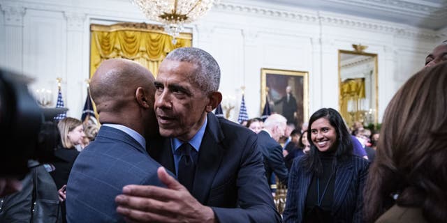 Former President Barack Obama hugs Jamal Simmons following an event about the Affordable Care Act and lowering health care costs for families in the East Room of the White House in Washington, D.C., on April 5, 2022.