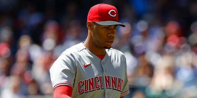 Hunter Greene #21 of the Cincinnati Reds returns to the dugout in the first inning of his MLB debut against the Atlanta Braves at Truist Park on April 10, 2022 in Atlanta, Georgia.