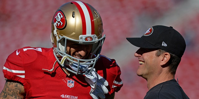 San Francisco 49ers head coach Jim Harbaugh laughs with his starting quarterback Colin Kaepernick (7) before a game against the Arizona Cardinals at Levi's Stadium in Santa Clara, Calif., Dec. 28, 2014. 