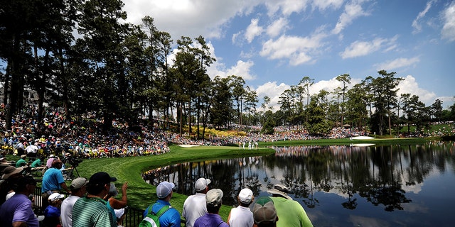 Golf fans line the railing and hillside near the ninth green during the Par 3 contest on Wednesday, April 8, 2015, at Augusta National Golf Club in Augusta, Ga. 