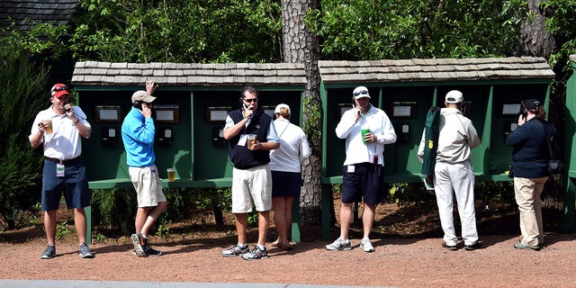 Patrons make phone calls during a practice round before the 80th Masters on April 6, 2016, in Augusta, Georgia.