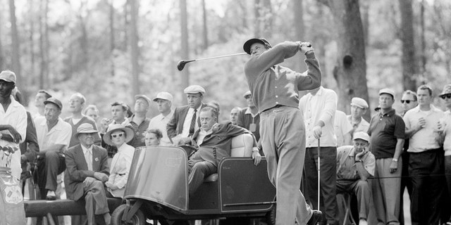 Horton Smith tees off as Bobby Jones watches during the 1956 Masters Tournament at Augusta National Golf Club in April 1956 in Augusta, Georgia. 