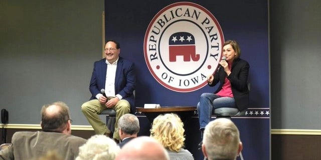 Iowa GOP Chair Jeff Kaufmann is joined by Iowa Republican Gov. Kim Reynolds at a party event in Council Bluffs, Iowa on Friday March 18, 2022