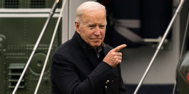 President Biden points to the Oval Office of the White House as he arrives on Marine One on the South Lawn in Washington Nov. 21, 2021.