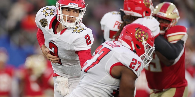 Luis Perez of New Jersey Generals hands the ball off to teammate Darius Victor against the Birmingham Stallions at Protective Stadium on April 16, 2022, in Birmingham, Alabama.