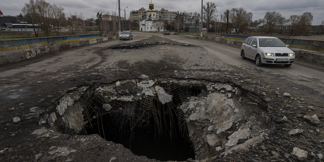 Cars drive near a damaged bridge following a Russian attack in the previous weeks in the town of Makarov in the Kyiv region on Sunday.