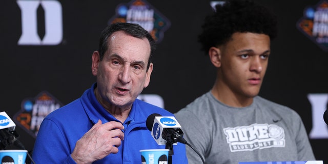 Head coach Mike Krzyzewski of the Duke Blue Devils talks to the press as Paolo Banchero #5 looks on after losing to the North Carolina Tar Heels 81-77 in the 2022 NCAA Men's Basketball Tournament Final Four semifinal at Caesars Superdome on April 2, 2022 in New Orleans, Louisiana.