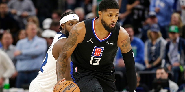 Los Angeles Clippers guard Paul George (13) drives past Minnesota Timberwolves guard Patrick Beverley (22) during the first quarter of a game Tuesday, April 12, 2022, in Minneapolis.