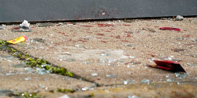 This is what appears to be blood and broken glass on the sidewalk outside the short-term rental property where police say a shooting took place at a house party in Pittsburgh early Sunday morning, April 17, 2022.