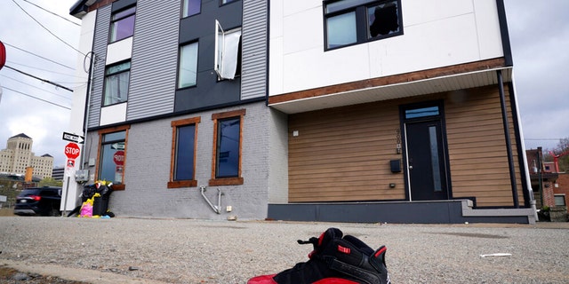 A lone sneaker lies near a short-term rental property where police say a shooting took place in Pittsburgh early Sunday morning, April 17, 2022. 