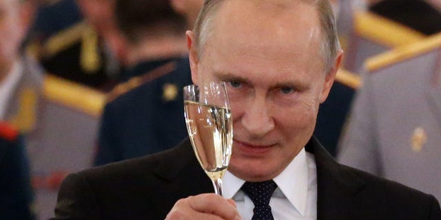 Russian President Vladimir Putin toasts during reception for military servicemen who took part in Syrian campaign, at Grand Kremlin Palace on December 28, 2017 in Moscow.