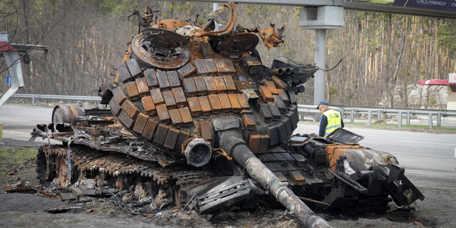 A damaged Russian tank is seen on a highway to Kyiv, Ukraine, on Monday.