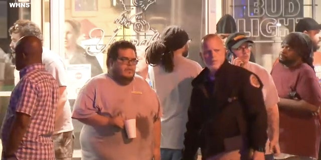 People standing across the street of a shooting incident in Anderson County, South Carolina (WHNS).