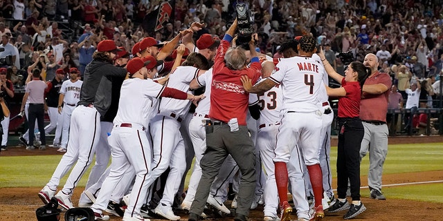 The Arizona Diamondbacks celebrate Seth Beer after hit hit a three run walk-off home run during the ninth inning of a baseball game against the San Diego Padres, Thursday, April 7, 2022, in Phoenix. The Diamondbacks won 4-2.