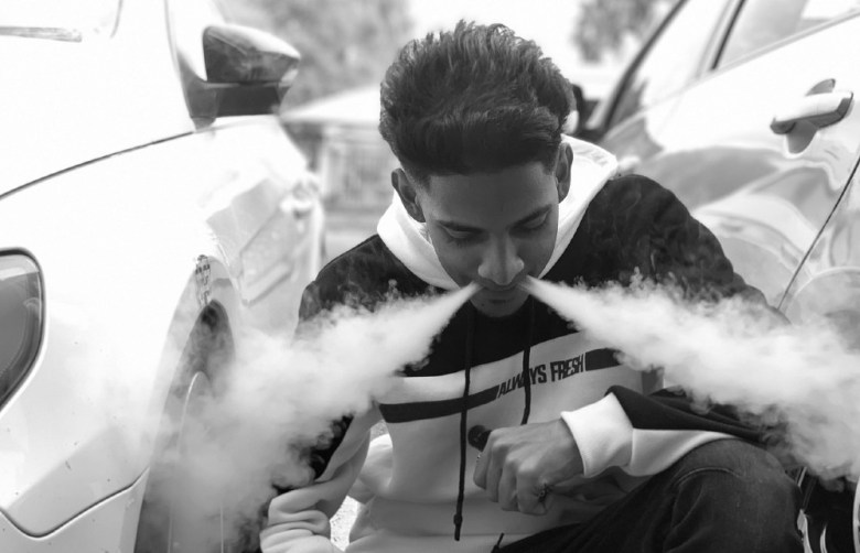 Teen smoking e-cigarette