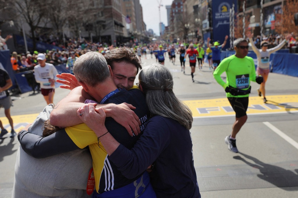 Henry hugging his parents  after finishing the Boston Marathon.