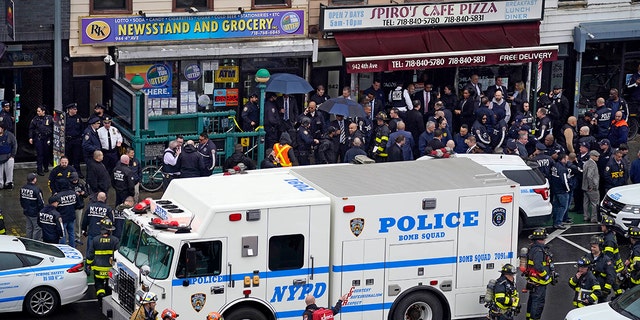 Emergency personnel gather at the entrance to a subway stop in Brooklyn, New York, Tuesday, April 12, 2022.