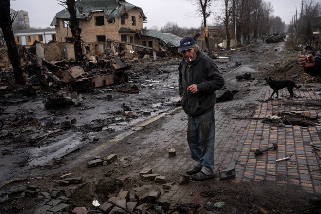 Konstyantyn, 70, smokes a cigarette amid destroyed Russian tanks in Bucha on the outskirts of Kyiv, Ukraine, on April 3.