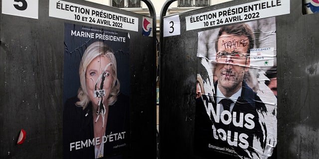 Campaign posters displayed on billboards next to a polling station April 4, 2022, in Paris. 