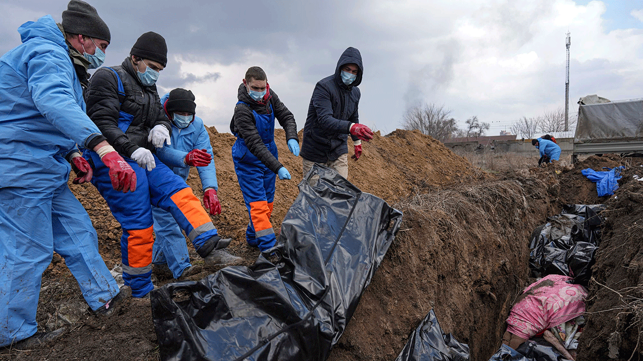 Dead bodies are placed into a mass grave on the outskirts of Mariupol, Ukraine, Wednesday, March 9, 2022, as people cannot bury their dead because of the heavy shelling by Russian forces. 