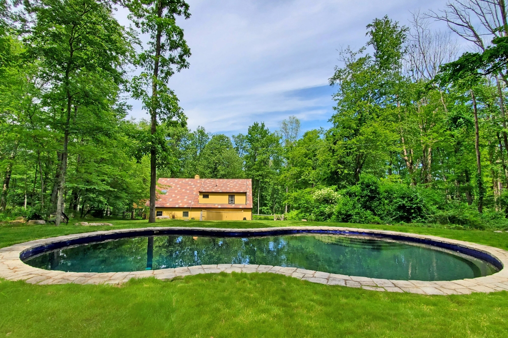 The grounds also include a gunite pool, along with a pool/carriage house.