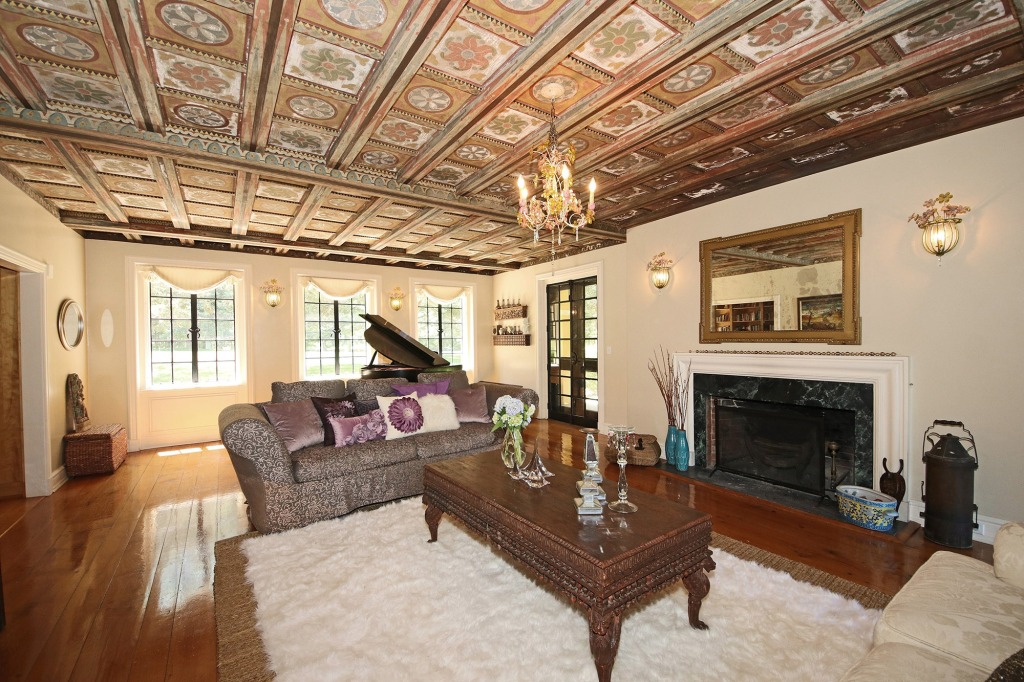The main house comes with a formal living area that stands under a painted coffered ceiling.