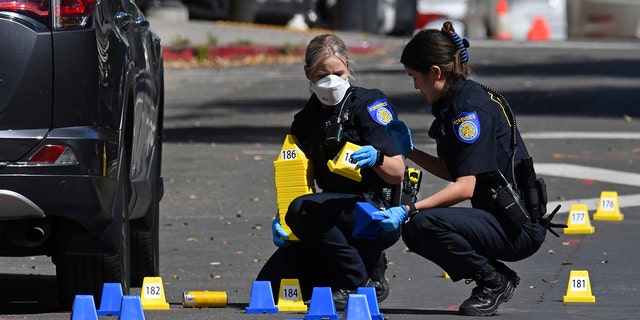 Sacramento Police crime scene investigators place evidence markers on 10th street at the scene of a mass shooting in Sacramento, Calif., on Sunday, April 3, 2022. 
