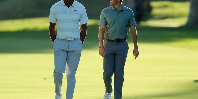 Tiger Woods and Rory McIlroy of Northern Ireland walk across the 17th hole during the second round of the Genesis Open at Riviera Country Club Feb. 16, 2018, in Pacific Palisades, Calif.