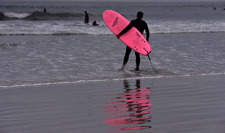 A surfer watches waves at La Jolla Shores beach. Photo by Chris Stone