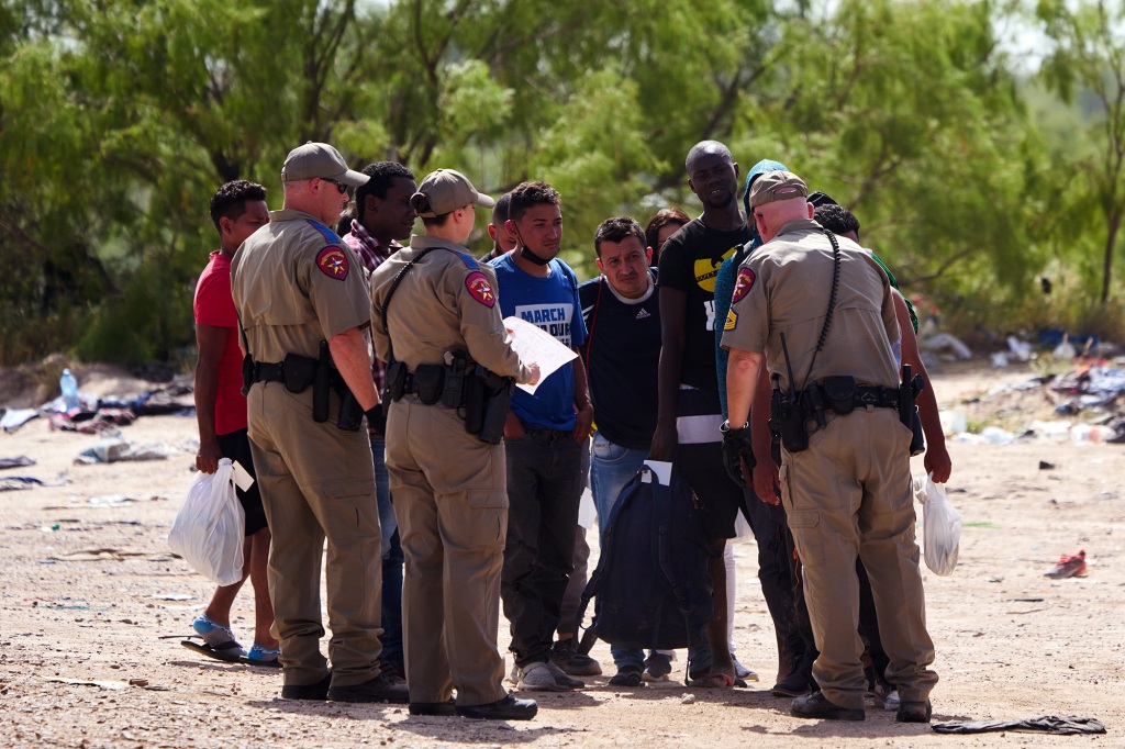 Migrants wait to be processed by U.S. Customs and Border Protection officers 