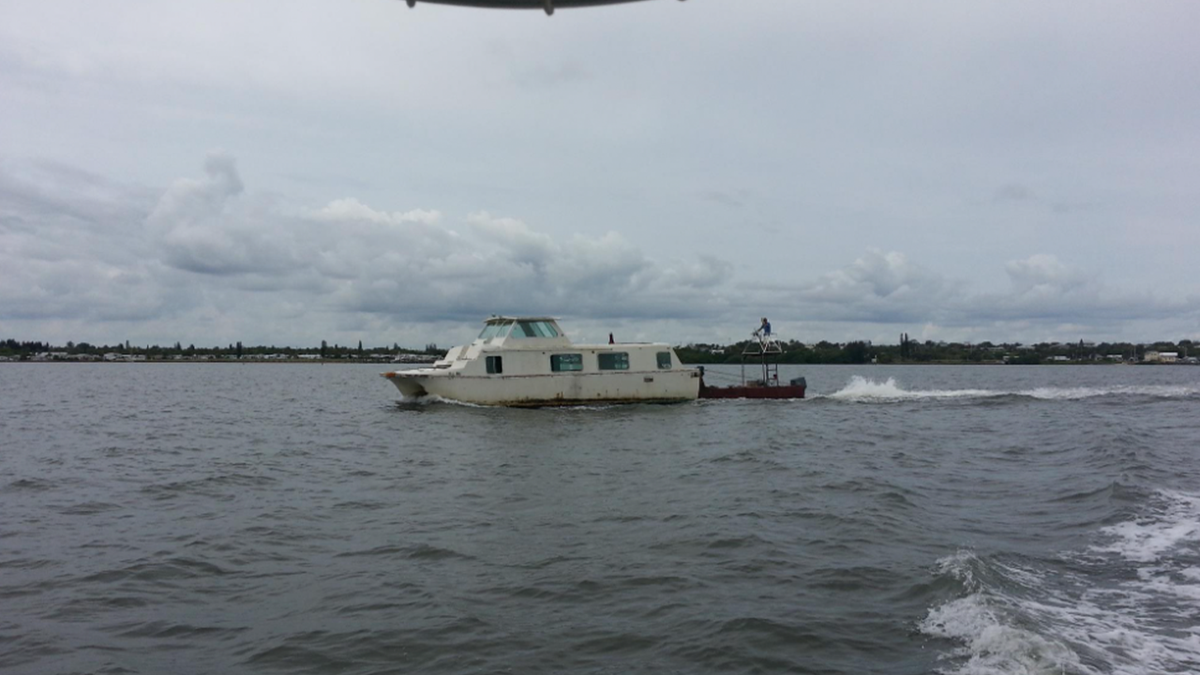 a derelict boat getting towed